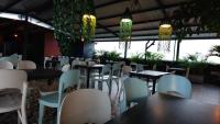 a restaurant with tables and white chairs and plants at Hotel Doral Inn in Ibagué