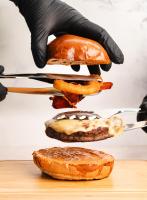 Een persoon met zwarte handschoenen houdt voedsel vast op een snijplank. bij Crowne Plaza Merida by IHG in Mérida