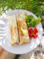 une assiette blanche avec deux sandwichs et une salade dans l'établissement The Twins Sunset Bungalow, à Palebah