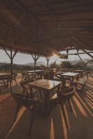 een groep tafels en stoelen onder een rieten paraplu bij Hotel Ambil in Barichara