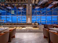 un ristorante con tavoli e sedie e grandi finestre di Orange Crystal Hotel Nanjing Drum Tower a Nanjing