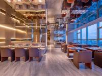 un ristorante con tavoli, sedie e finestre di Orange Crystal Hotel Nanjing Drum Tower a Nanjing