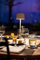 a table with wine glasses and a lamp on it at Hôtel de la Paix Lausanne in Lausanne