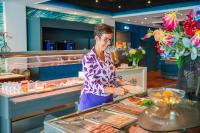 a woman preparing food in a buffet at Hotel Zwartewater in Zwartsluis