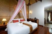 a bedroom with a large white bed with pink drapes at PingChan Koh Phangan Beachfront Resort in Thong Nai Pan Yai