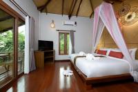 a bedroom with a bed with a mosquito net at PingChan Koh Phangan Beachfront Resort in Thong Nai Pan Yai