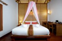 a bedroom with a bed with white sheets and red pillows at PingChan Koh Phangan Beachfront Resort in Thong Nai Pan Yai