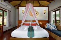 a bedroom with a bed with a mosquito net at PingChan Koh Phangan Beachfront Resort in Thong Nai Pan Yai