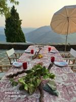 een tafel met een tafelkleed en een parasol bij Casa De Casal De Loivos in Pinhão