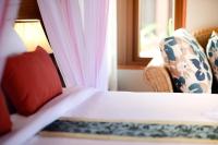 a bedroom with a bed and a chair and a window at PingChan Koh Phangan Beachfront Resort in Thong Nai Pan Yai