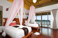 a bedroom with two beds with mosquito nets and windows at PingChan Koh Phangan Beachfront Resort in Thong Nai Pan Yai