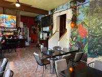 a restaurant with tables and chairs and a bar at Casa de Leyendas in Mazatlán