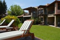 two lawn chairs sitting on a deck in a yard at Lares De Chacras in Chacras de Coria