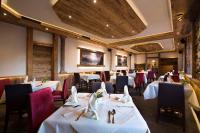 因斯布鲁克因斯布鲁克莱比锡霍夫酒店的摆放着白色桌椅的餐厅