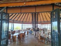 ein Esszimmer mit Tischen, Stühlen und Fenstern in der Unterkunft Rai Ruen Rom Organic and Farmstay in Ban Sawan