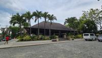 a large building with palm trees in front of it at Maria Clara Villas in Panabo