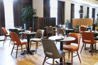 een eetkamer met tafels en stoelen en ramen bij Fosshotel Reykjavík in Reykjavík