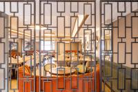 een kamer met oranje stoelen en tafels en een muur met een patroon bij Regnum Bansko Ski Hotel & SPA in Bansko