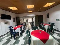 un ristorante con tavoli e sedie rossi e una TV a schermo piatto di Hotel Venecia Confort a Pasto