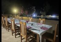 a long table with chairs and a table set for dinner at Kabacoto Lodges in Darou Rhamane