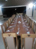 a long wooden table with chairs and glasses on it at Kabacoto Lodges in Darou Rhamane