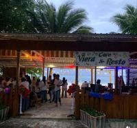 a group of people standing outside of a cafe near the ocean at Viera Resort in Ngurblut
