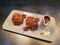 a white plate with two donuts and a dipping sauce at Cottage Logis Hôtel - Restaurant in Dudelange