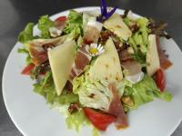 un piatto bianco con un'insalata con formaggio e lattuga di Entre Lacs et Volcans ad Aydat