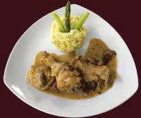 un piatto bianco di cibo con carne e riso e una succulenta uanauanauana di Entre Lacs et Volcans ad Aydat