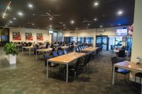 een eetkamer met houten tafels en stoelen bij Sundowner Motel Hotel in Whyalla