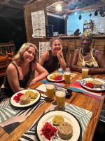 three women sitting at a table with plates of food at Madre Selva Eco Lodge in Nuquí