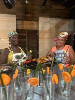 two women standing in front of a table of food at Madre Selva Eco Lodge in Nuquí