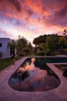 a swimming pool with a cloudy sky in a yard at Onse Rus Guesthouse in Prince Albert