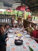 Grand Selva Lodge & Tours في تينا: مجموعة من الأشخاص يجلسون حول طاولة طعام