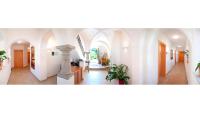 a hallway with white walls and arches and plants at Bauernhofpension Herzog zu Laah in Linz