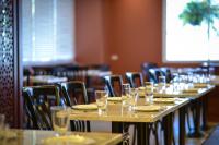a row of tables in a restaurant with glasses on them at Hisea Huahin Hotel in Hua Hin