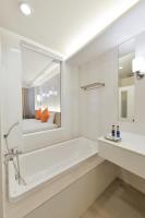 a bathroom with a tub and a sink and a mirror at Hisea Huahin Hotel in Hua Hin