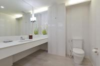 a white bathroom with a toilet and a sink at Hisea Huahin Hotel in Hua Hin
