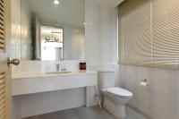 a white bathroom with a toilet and a sink at Hisea Huahin Hotel in Hua Hin