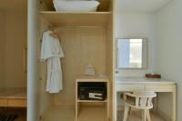 a bathroom with a sink and a mirror and a closet at Hisea Huahin Hotel in Hua Hin