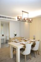 a dining room table with chairs and a light fixture at Hisea Huahin Hotel in Hua Hin