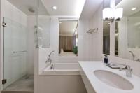 a white bathroom with a sink and a shower at Hisea Huahin Hotel in Hua Hin