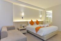 a bedroom with a bed with a chair and a mirror at Hisea Huahin Hotel in Hua Hin