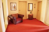 a living room with a chair and a red carpet at Pension Post in Twiste