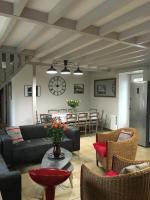 a living room with a couch and chairs and a table at Fleur House in Teloché