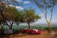 a table set up inront of a fence with trees at Lake Manyara Serena Safari Lodge in Karatu