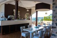 Un restaurante con mesas y sillas y un bar. en Dominio Mare Resort & SPA, en Bergeggi