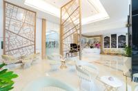 a lobby with white chairs and tables in a building at Bandara Suites Silom, Bangkok in Bangkok
