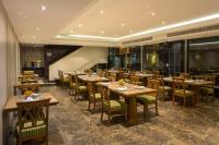 a dining room with wooden tables and chairs at Bandara Suites Silom, Bangkok in Bangkok