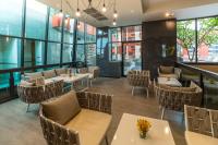 a restaurant with tables and chairs and windows at Bandara Suites Silom, Bangkok in Bangkok